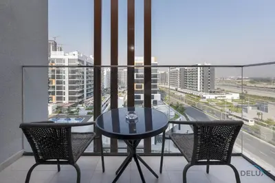 a table and two chairs on a balcony with a view at Inviting Studio Apartment at Azizi Riviera 36 in Al Merkadh by Deluxe Holiday Homes in Dubai