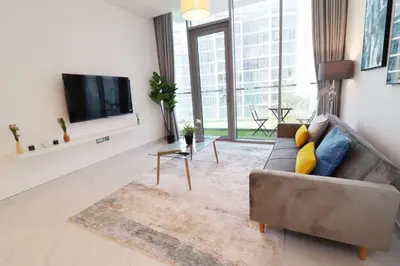 a living room with a couch and a flat screen tv at Stellar Dreams 1BR - District 1 in Dubai