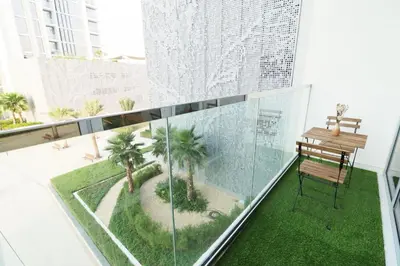 a balcony with a bench and palm trees on it at Stellar Dreams 1BR - District 1 in Dubai