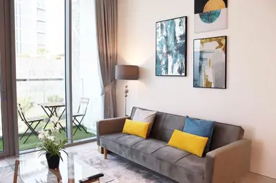 a living room with a gray couch and yellow pillows at Stellar Dreams 1BR - District 1 in Dubai