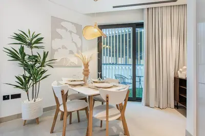 a dining room with a white table and chairs at STAY BY LATINEM Luxury 2BR Holiday Home W204 near Burj Khalifa in Dubai