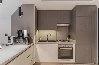 a kitchen with a sink and a stove top oven at Modern Studio with Pool View & Gym Access in Dubai
