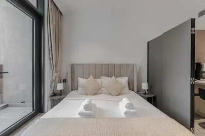 a bedroom with a bed with towels on it at Modern Studio with Pool View & Gym Access in Dubai