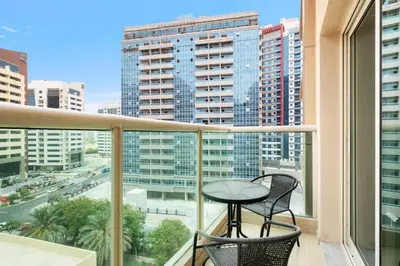 a balcony with a table and chairs and a view of a city at New Studio in Sport City - Pool, Gym, Parking in Dubai