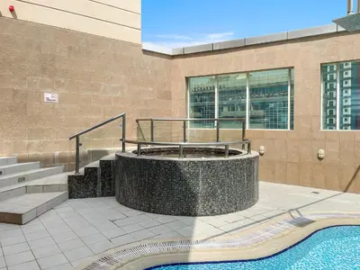 a building with a staircase and a swimming pool at New Studio in Sport City - Pool, Gym, Parking in Dubai