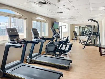 a gym with several treadmills and elliptical machines at New Studio in Sport City - Pool, Gym, Parking in Dubai