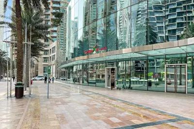 a city street with a large glass building at Luxury 4BR Flat, Downtown Dubai, Pool, Gym, PS5, Sleeps 11 Guests in Dubai