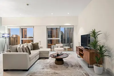 a living room with a white couch and a tv at FIRST CLASS 1BR Luxury Living in DIFC in Dubai