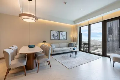 a living room with a couch and a table and chairs at Deluxe 3BR Home in Address Opera with Full Burj View in Dubai