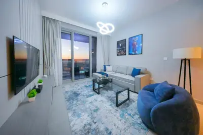 a living room with a blue couch and a tv at PrimeForte Walk to Dubai Mall in Dubai