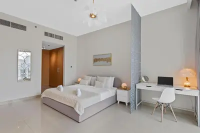 a white bedroom with a bed and a desk at Luxurious Living 3 Bedroom at Harbour Views in Dubai