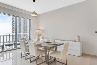 a dining room with a table and chairs and a balcony at Luxurious Living 3 Bedroom at Harbour Views in Dubai