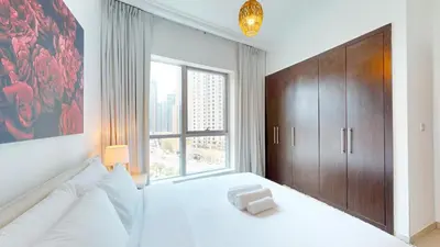 a bedroom with a white bed and a large window at Bay Central 2 - Charming One Bedroom in Dubai