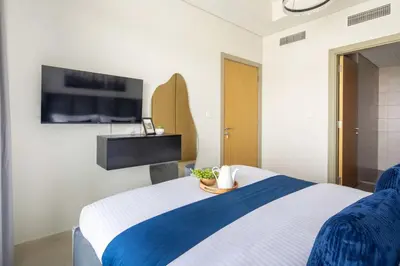 a bedroom with a bed with a tv on the wall at Frank Porter - Aykon City Tower C in Dubai