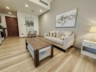 a living room with a couch and a table at Rare Holiday Homes - Lake View - The Crescent Tower - Dubai Production City - R1611 in Dubai