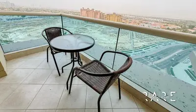 two chairs and a table on a balcony with a view at Rare Holiday Homes - Lake View - The Crescent Tower - Dubai Production City - R1611 in Dubai