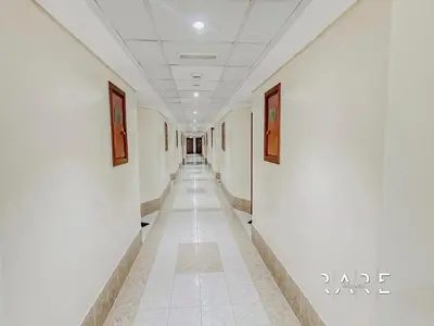 a hallway with white walls and paintings on the walls at Rare Holiday Homes - Lake View - Near Me'aisem City Centre - The Crescent Tower A - Dubai Production City - R910 in Dubai