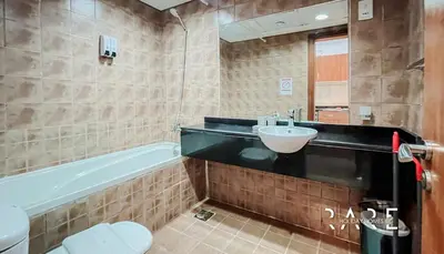 a bathroom with a sink and a tub and a toilet at Rare Holiday Homes - Lake View - Near Me'aisem City Centre - The Crescent Tower A - Dubai Production City - R910 in Dubai