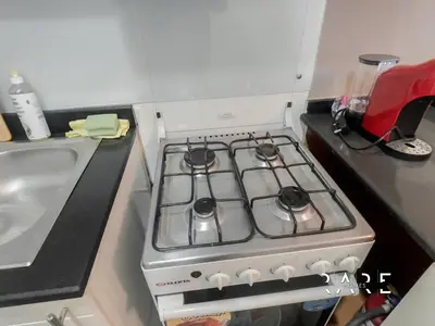 a stove top oven in a kitchen next to a sink at Rare Holiday Homes - Near The Lake - Lago Vista B - Dubai Production City - IMPZ - R2112 in Dubai