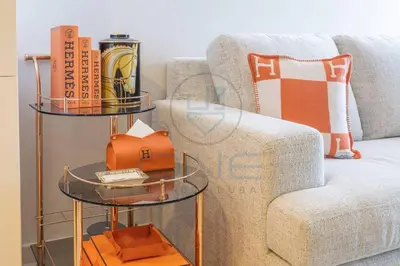 a side table with books on it next to a couch at Designer 1BR on High Floor Downtown Vibes in Dubai