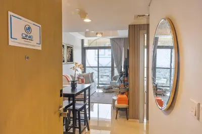 a living room with a table and a mirror at Designer 1BR on High Floor Downtown Vibes in Dubai