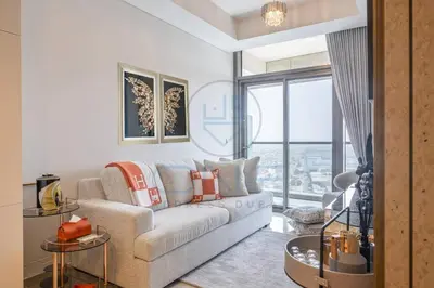a living room with a couch and a large window at Designer 1BR on High Floor Downtown Vibes in Dubai