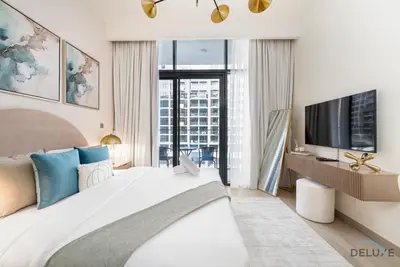 a bedroom with a large bed and a tv at Comfortable Studio in Azizi Riviera 24, Al Merkadh by Deluxe Holiday Homes in Dubai