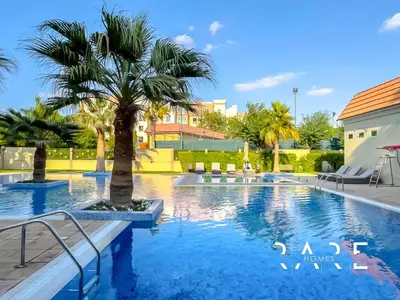 a swimming pool with a palm tree in a resort at Rare Holiday Homes - Mediterranean Cluster - Near Ibn Battuta Mall - Discovery Garden - Building# Med 49 - R514 in Dubai