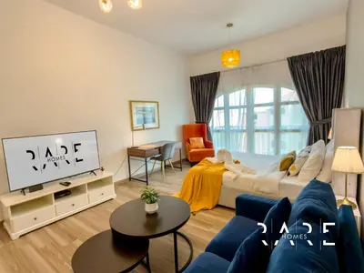 a living room with a bed and a tv at Rare Holiday Homes - Mediterranean Cluster - Near Ibn Battuta Mall - Discovery Garden - Building# Med 49 - R514 in Dubai