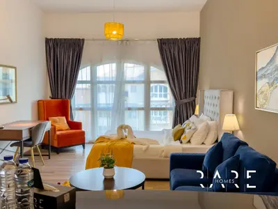 a living room with a large window and a couch at Rare Holiday Homes - Mediterranean Cluster - Near Ibn Battuta Mall - Discovery Garden - Building# Med 49 - R514 in Dubai