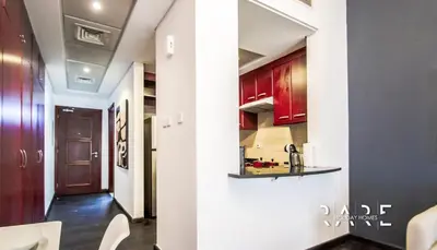 a kitchen with red cabinets and a hallway at Rare Holiday Homes - Mediterranean Cluster - Near Ibn Battuta Mall - Discovery Garden - Building# Med 49 - R411 in Dubai