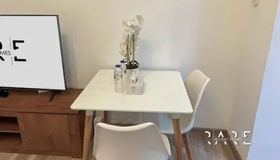 a white table with white chairs and a white board at Rare Holiday Homes - Mediterranean Cluster - Near Ibn Battuta Mall - Discovery Garden - Building# Med 49 - R106 in Dubai