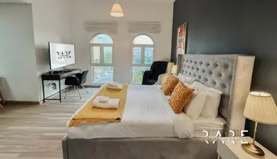 a bedroom with a large bed and a desk at Rare Holiday Homes - Mediterranean Cluster - Near Ibn Battuta Mall - Discovery Garden - Building# Med 79 - R203 in Dubai