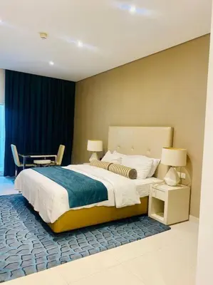 a bedroom with a large bed and a table at Downtown Studio - Cour Jardin in Dubai
