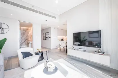 a white living room with a tv and a white chair at Waterfront Living 2BR Apartment in Marina Star, Dubai Marina by Deluxe Holiday Homes in Dubai