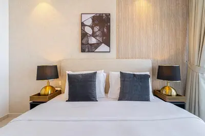 a bedroom with a large bed with two lamps at 3 King Beds - 7mins to Dubai Mall - High Floor Sun Set and Sea View in Dubai