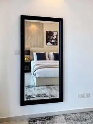 a mirror on a white wall in a bedroom at 3 King Beds - 7mins to Dubai Mall - High Floor Sun Set and Sea View in Dubai