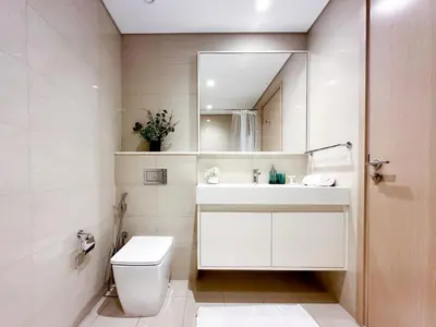 a bathroom with a toilet and a sink and a mirror at Breathtaking Burj View, Sky High Luxury 2BR Apartment by 2nd Best Home in Dubai
