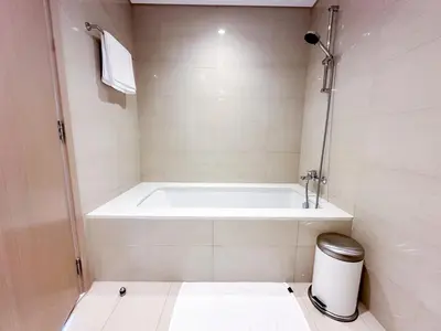a white bath tub in a bathroom with a trash can at Breathtaking Burj View, Sky High Luxury 2BR Apartment by 2nd Best Home in Dubai