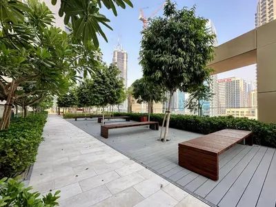 a park with benches and trees and buildings at Breathtaking Burj View, Sky High Luxury 2BR Apartment by 2nd Best Home in Dubai