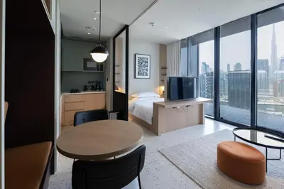 a hotel room with a bed and a table with a television at Modern Studio at Upside Living, Business Bay with Burj Khalifa View in Dubai