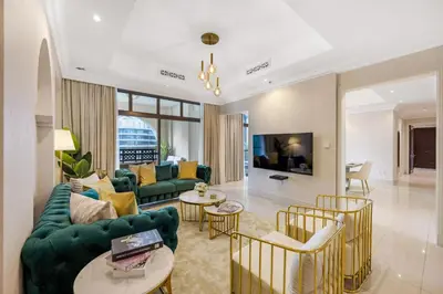 a living room with a green couch and chairs at Durrani Homes - Heaven on Earth collection 4BR with panorama Burj khalifa and fountain views in Dubai