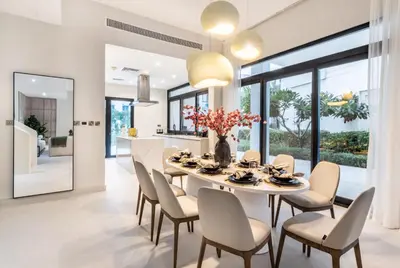 a dining room with a white table and chairs at Luxury Palm Villa with Beach Access -Rooftop Garden & Resort Style Pool by Exclusive Holiday Homes in Dubai