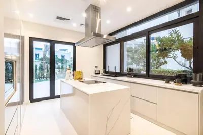 a kitchen with white counters and large windows at Luxury Palm Villa with Beach Access -Rooftop Garden & Resort Style Pool by Exclusive Holiday Homes in Dubai