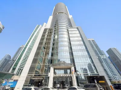 a tall building with cars parked in front of it at Silkhaus Modern Studio near Almas in West Lake in Dubai