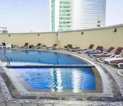 a large swimming pool with lounge chairs and a building at Silkhaus Modern Studio near Almas in West Lake in Dubai