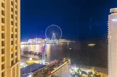 a large ferris wheel in a city at night at Bright 3BR Apartment in JBR Close to Beach & Shops in Dubai