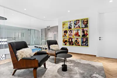 a living room with two chairs and a painting on the wall at Bright 3BR Apartment in JBR Close to Beach & Shops in Dubai