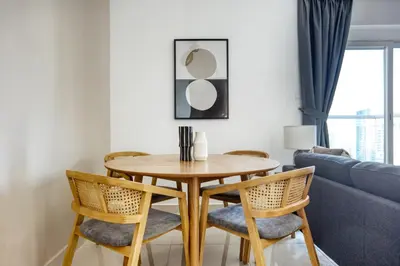 a dining room table with chairs and a couch at Blueground Marina Pool Gym DXB-221 in Dubai