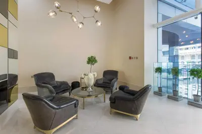 a waiting room with chairs and a table and a chandelier at Blueground Marina Pool Gym DXB-221 in Dubai